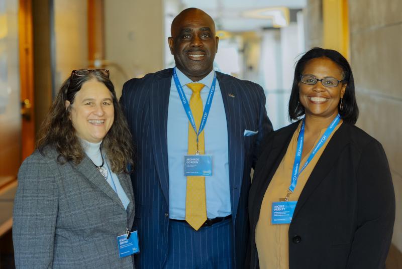 two women and one man dressed in business formal clothing smiling at the camera