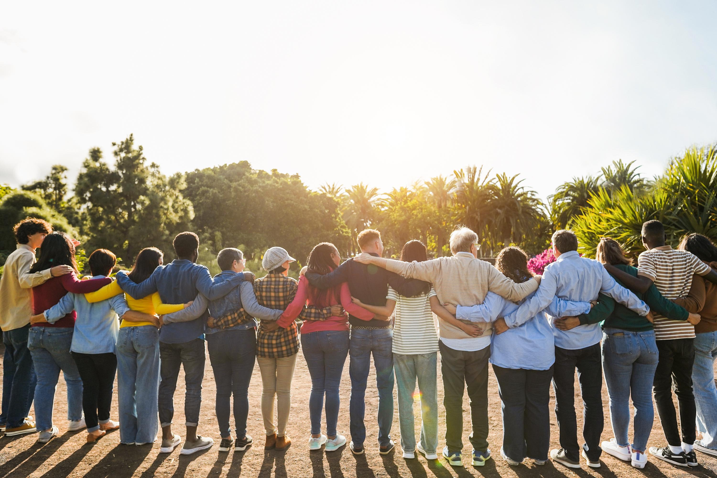 Several people holding each other in a line, view from the back.