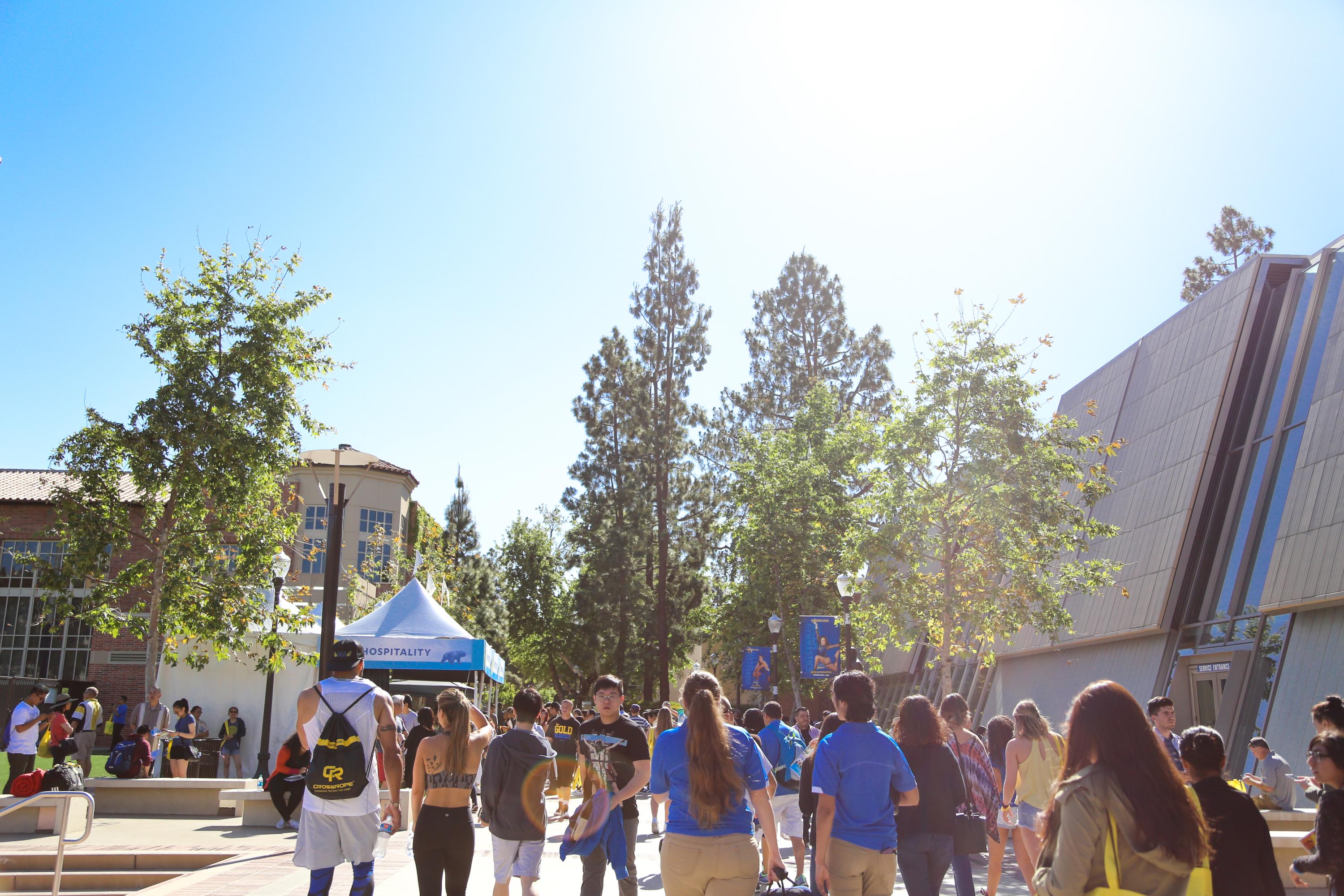 Students walk by Pauley Pavilion at UCLA on a sunny day. 