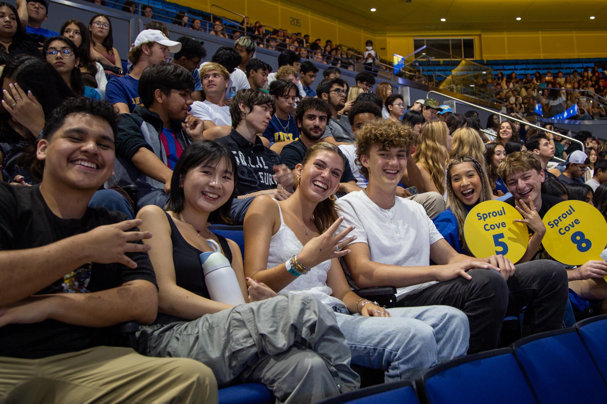 Students at UCLA's New Student Welcome holding 4 fingers up.