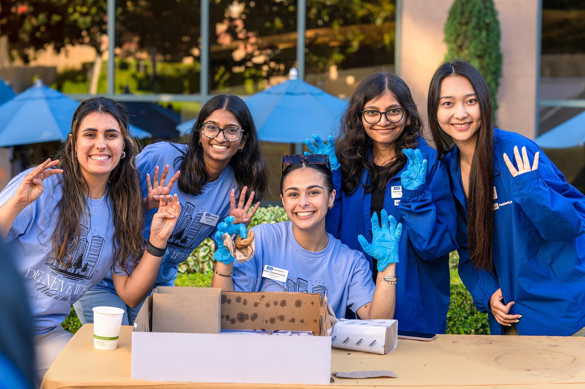 5 students at an event with 4 fingers up.