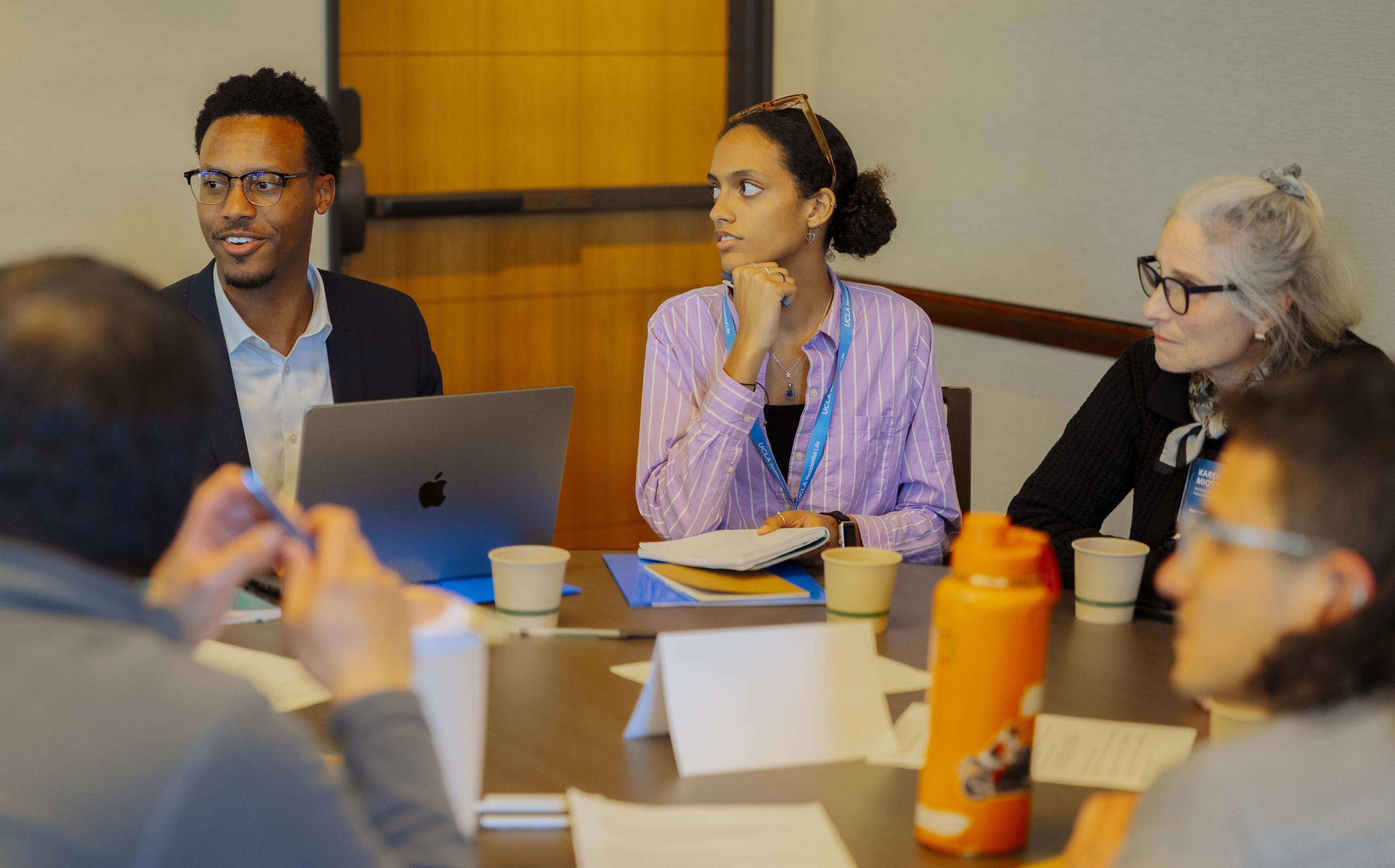 Group of people listening intently at a table.