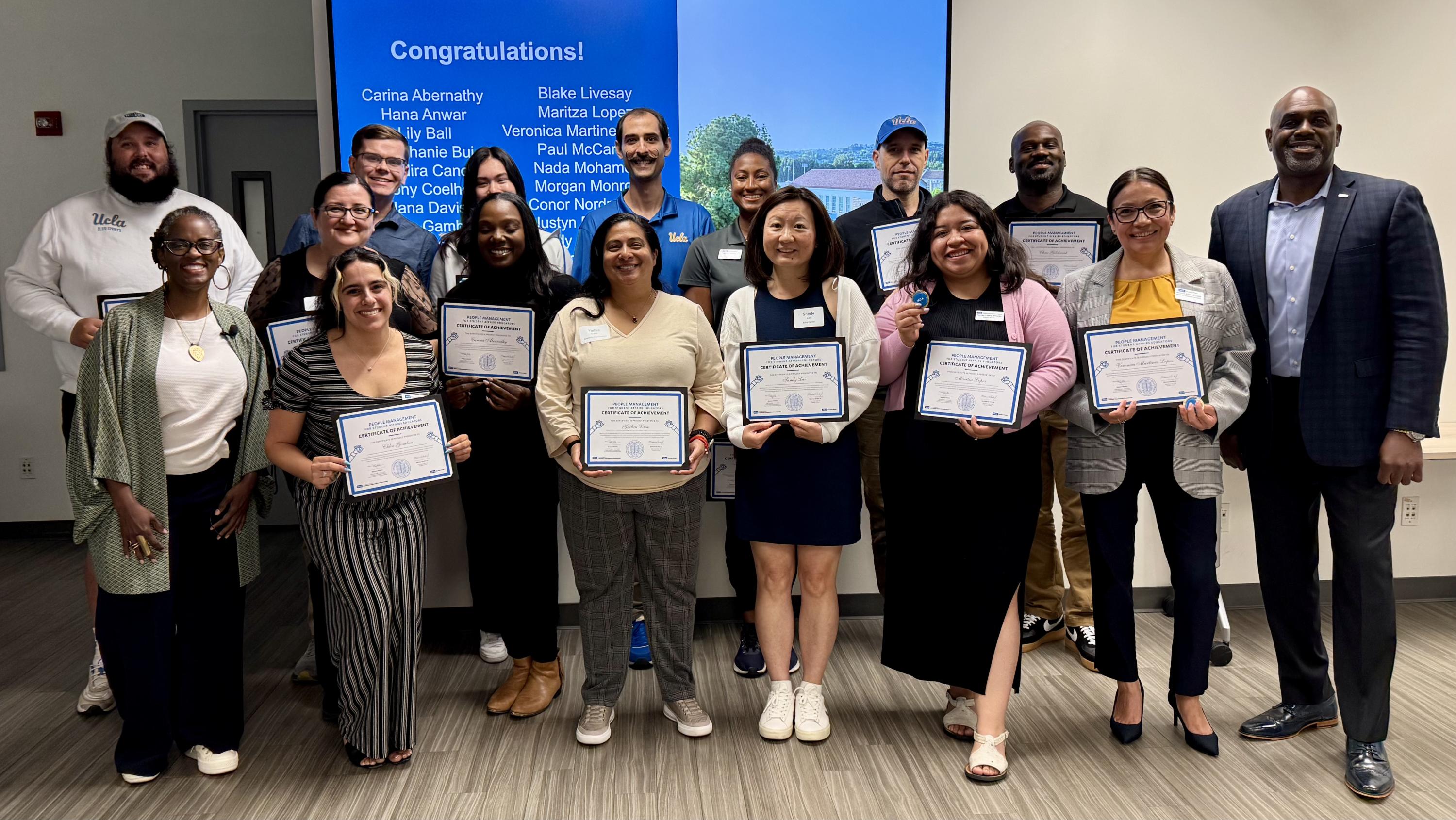 Educators pose smiling with the certificates they earned