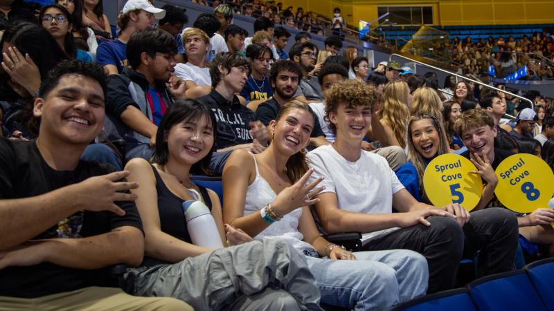 Students at UCLA's New Student Welcome holding 4 fingers up.