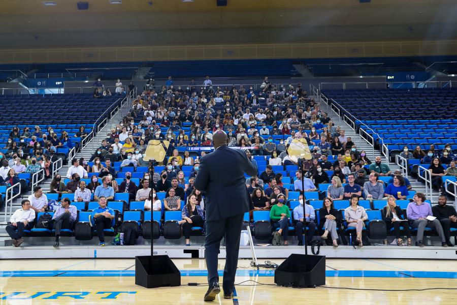 Back of Vice Chancellor Monroe Gordon speaking to staff in Pauley Pavilion